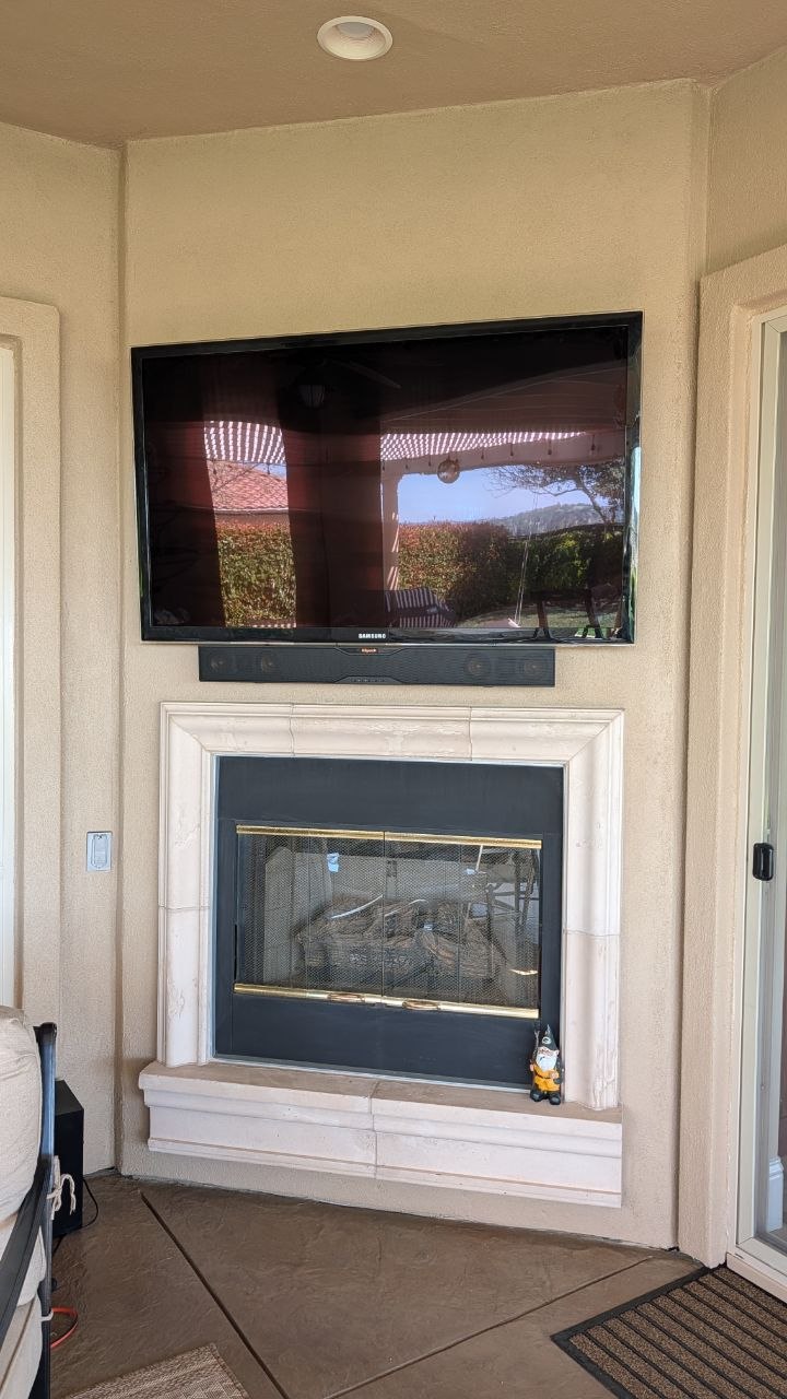 Samsung TV and Klipsch soundbar mounted above stucco fireplace in Folsom, CA